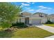 Beautifully landscaped front yard with a well-maintained lawn and a two-car garage at 902 Grand Hilltop Dr, Apopka, FL 32703