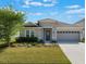 Inviting single-story home with a neatly manicured lawn and a two-car garage at 902 Grand Hilltop Dr, Apopka, FL 32703