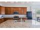 Kitchen featuring an island with granite countertops, a stainless steel sink, and cabinets, perfect for food preparation at 902 Grand Hilltop Dr, Apopka, FL 32703