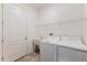 Well-lit laundry room with washer, dryer, utility sink and a wire rack for ample storage space at 902 Grand Hilltop Dr, Apopka, FL 32703