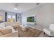 Spacious living room with a plush sectional, modern decor, and large windows at 902 Grand Hilltop Dr, Apopka, FL 32703