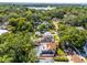 Aerial view of home with screened pool, rooftop deck, lush landscaping, and community lake at 910 Alameda St, Orlando, FL 32804