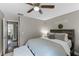 Comfortable bedroom featuring ceiling fan, warm, neutral paint, and view into en-suite bathroom at 2652 Laser Ct, Orlando, FL 32826