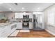 Modern kitchen featuring white cabinets, stainless steel appliances, and hardwood floors at 2652 Laser Ct, Orlando, FL 32826