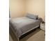 Cozy bedroom features a bed with grey striped bedding and a side table with drawers at 6327 Southbridge St, Windermere, FL 34786