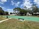 Outdoor basketball court featuring a green surface, hoops, benches, and surrounding green space at 14220 Morning Frost Dr, Orlando, FL 32828