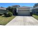 Charming single-Gathering home with a two-car garage and well-maintained landscaping and large driveway at 14220 Morning Frost Dr, Orlando, FL 32828