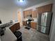 Well-equipped kitchen with stainless steel appliances, wooden cabinets, and durable tile flooring at 14220 Morning Frost Dr, Orlando, FL 32828