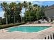 Community pool with lounge chairs and a spa surrounded by tall palm trees and greenery at 14220 Morning Frost Dr, Orlando, FL 32828