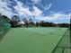Well-maintained community tennis courts with green surface, enclosed by a fence and lush trees at 14220 Morning Frost Dr, Orlando, FL 32828