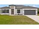 Charming single-story home featuring a gray two-car garage and a well-manicured lawn under a bright blue sky at 15046 Sw 48Th Ave, Ocala, FL 34473