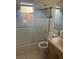 Bathroom featuring a tub with sliding glass doors, complemented by a modern sink and toilet at 1909 Lady Ave, Ocoee, FL 34761