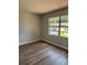 Cozy bedroom with neutral paint, wood-look flooring, and a window offering neighborhood views at 1909 Lady Ave, Ocoee, FL 34761