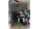 Garage filled with storage and clutter on the ground including work bench and a ceiling fan at 1909 Lady Ave, Ocoee, FL 34761
