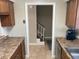 View of the kitchen leading to the carpeted staircase with brown cabinets and granite countertops at 2141 Lake Margaret Dr # 11, Orlando, FL 32806