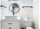 Modern bathroom featuring shiplap walls, round mirror, and a stylish vanity with black hardware at 2614 Parkland Dr, Winter Park, FL 32789