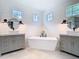 Luxurious bathroom featuring a soaking tub, dual vanities, and shiplap walls with a modern design at 2614 Parkland Dr, Winter Park, FL 32789