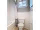 Bathroom with tiled walls, tub, and white toilet at 2614 Parkland Dr, Winter Park, FL 32789