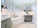 Bright bathroom with a soaking tub, dual vanities, shiplap walls, and modern fixtures with ample natural light at 2614 Parkland Dr, Winter Park, FL 32789