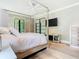 Relaxing bedroom with a canopy bed, hardwood floors, tv, and a minimalist design that maximizes natural light at 2614 Parkland Dr, Winter Park, FL 32789
