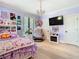 Bright bedroom featuring whimsical artwork, a cozy bed, and a playful hanging chair, creating a vibrant space at 2614 Parkland Dr, Winter Park, FL 32789