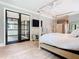 Bright bedroom with a canopy bed, hardwood floors, tv, and access to the outside with glass doors at 2614 Parkland Dr, Winter Park, FL 32789
