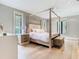 Comfortable bedroom with a canopy bed, hardwood floors, and neutral color scheme with large windows at 2614 Parkland Dr, Winter Park, FL 32789
