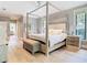 Serene bedroom features a canopy bed, hardwood floors, and neutral decor with ample natural light at 2614 Parkland Dr, Winter Park, FL 32789