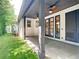 Inviting covered patio with ceiling fans, access to the yard and stylish black framed doors and trim at 2614 Parkland Dr, Winter Park, FL 32789