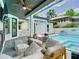 A spacious outdoor living area is equipped with a fireplace and overlooks the beautiful pool at 2614 Parkland Dr, Winter Park, FL 32789