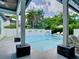 View of the pool from a covered patio with seating and decorative wall features at 2614 Parkland Dr, Winter Park, FL 32789