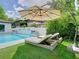 Relaxing poolside view features lounge chairs under an umbrella with lush greenery at 2614 Parkland Dr, Winter Park, FL 32789