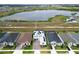 Aerial shot of a neighborhood featuring homes with solar panels and a scenic view of a nearby lake at 2926 Crest Wave Dr, Clermont, FL 34711
