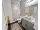 Modern powder room boasting unique marble wallpaper, a vessel sink, and stylish lighting at 2926 Crest Wave Dr, Clermont, FL 34711
