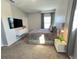 Cozy bedroom with a king-sized bed, soft gray carpet and curtains, and a modern wall mounted TV at 2926 Crest Wave Dr, Clermont, FL 34711