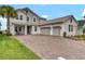 Charming two-story home featuring a three-car garage and brick-paved driveway at 2926 Crest Wave Dr, Clermont, FL 34711