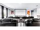 A home theater room with tiered seating, a large screen, and M&M wall art, creating an immersive entertainment experience at 2926 Crest Wave Dr, Clermont, FL 34711