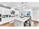 Modern kitchen with white cabinets, marble countertops, island with seating, and stainless steel appliances at 2926 Crest Wave Dr, Clermont, FL 34711