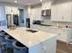 Modern kitchen featuring a large island with seating, stainless steel appliances, and sleek white cabinetry at 2926 Crest Wave Dr, Clermont, FL 34711
