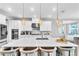 Open kitchen featuring a marble island with seating, pendant lighting, and stainless steel appliances at 2926 Crest Wave Dr, Clermont, FL 34711