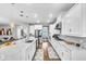 Open kitchen with an island with seating, white cabinets, stainless steel appliances, and hardwood floors at 2926 Crest Wave Dr, Clermont, FL 34711