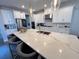 Open kitchen with white cabinets, a large island with barstools, and stylish pendant lighting at 2926 Crest Wave Dr, Clermont, FL 34711