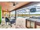Covered patio with dining area, outdoor kitchen, lake view, basketball hoop, and screened-in pool at 2926 Crest Wave Dr, Clermont, FL 34711