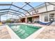 A luxurious screened-in pool area featuring a spa and lounge seating at 2926 Crest Wave Dr, Clermont, FL 34711