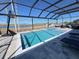 Beautiful pool and spa combination within a screened enclosure, offering a private oasis for relaxation and fun with a view of a nearby lake at 2926 Crest Wave Dr, Clermont, FL 34711