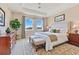 Serene bedroom featuring a tray ceiling, and a comfortable king bed, complemented by natural light from the large windows at 11630 Flynn Ct, Winter Garden, FL 34787