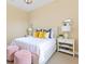 Bright bedroom featuring a white bed, nightstands with lamps, and decorative pink ottomans for a cozy touch at 11630 Flynn Ct, Winter Garden, FL 34787