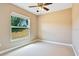 Neutral bedroom with ceiling fan, window view of backyard, and carpeted floors at 11630 Flynn Ct, Winter Garden, FL 34787
