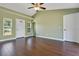 Bright living room featuring hardwood floors, two windows, a ceiling fan, and neutral paint at 11630 Flynn Ct, Winter Garden, FL 34787