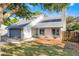Charming one-story home with a gray roof, a gray garage door, and mature trees at 1220 Rolling Ln, Casselberry, FL 32707